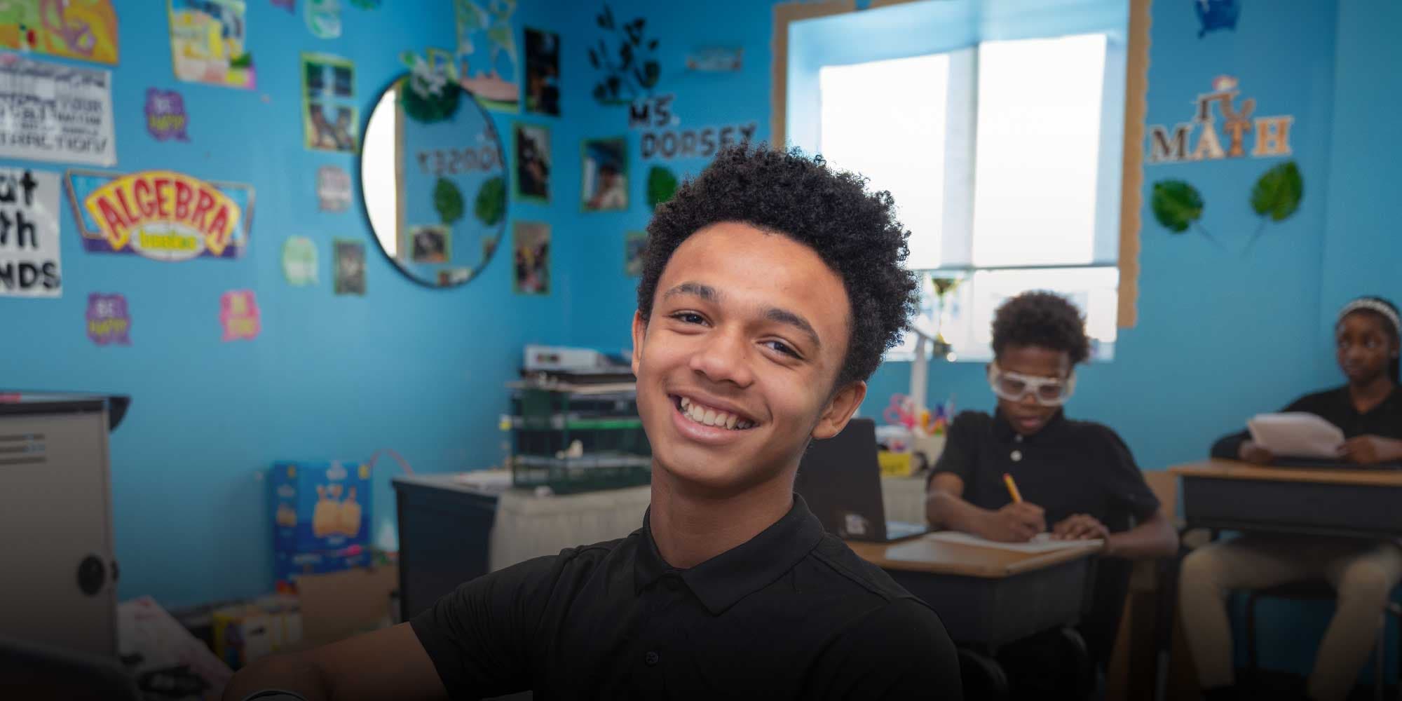 Smiling middle school student in a math classroom.